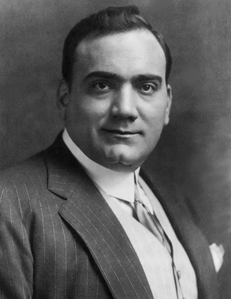 Black-and-white studio portrait of the tenor Enrico Caruso in a pinstriped suit